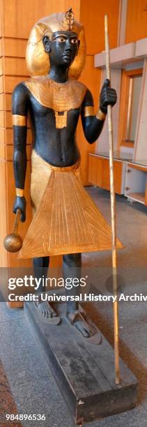 Replication of a gilded wooden guardian statues from King Tutankhamen's burial chamber. Tutankhamen was an Egyptian pharaoh of the 18th dynasty ....