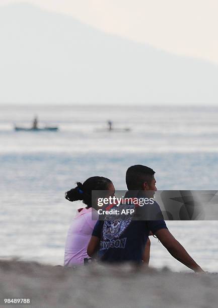 To go with AFP story by Matt Crook: TIMOR-WOMEN-EDUCATION-YOUTH-FAMILY A young couple sit together on the beach in Dili on March 28, 2010. The...