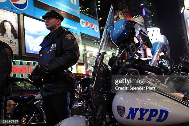 Police officer stands near his motorcycle in Times Square on April 15, 2010 in New York City. Following a recent melee involving groups of youths...