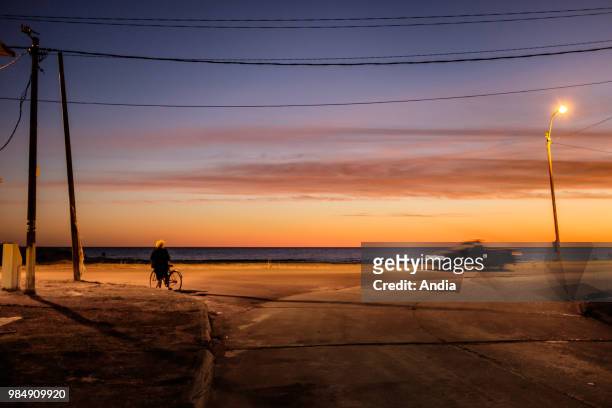Uruguay, La Floresta, small city and resort on the Costa de Oro . At dusk, seashore atmosphere, with a car and a bike. Street lamp lighting.
