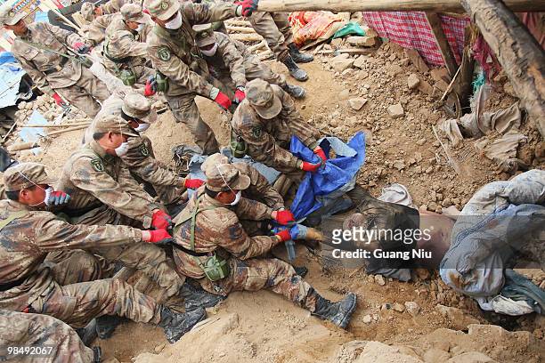 Chinese soldiers remove a body from the rubble of a collapsed building following a strong earthquake, on April 16 in Jiegu, near Golmud, China. It is...