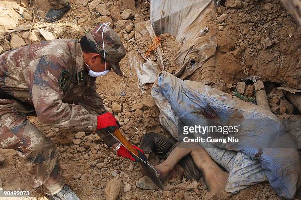 Chinese soldier digs rubble to remove a body from a collapsed building following a strong earthquake, on April 16, 2010 in Jiegu, near Golmud, China....