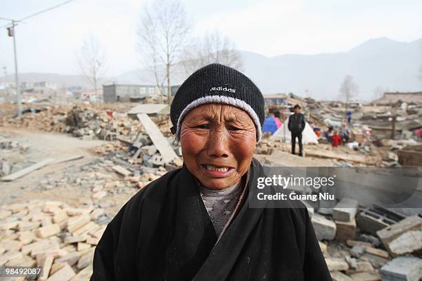 An elderly Tibetan woman cries as she looks towards her home that was demolished in a strong earthquake, on April 16, 2010 in Jiegu, near Golmud,...