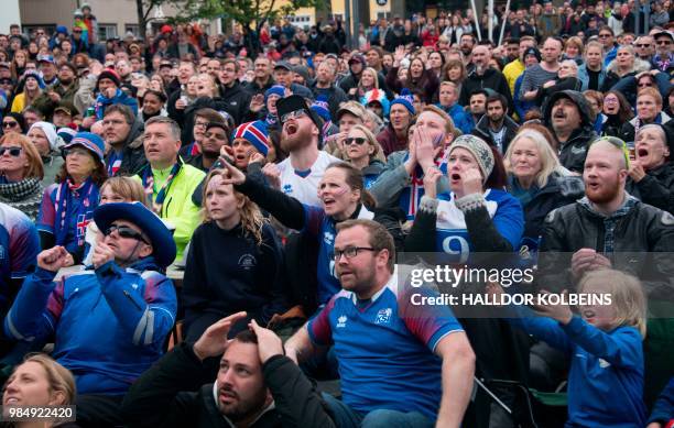 Supporters of the Icelandic national football team react as they watch on a giant screen the Russia 2018 World Cup Group D football match between...