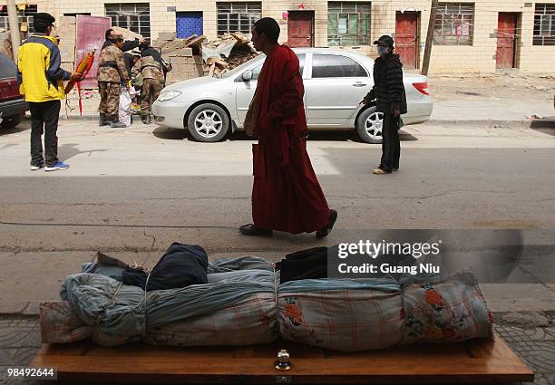 Monk walks past a body wrapped and waiting for collection following a strong earthquake, on April 16, 2010 in Jiegu, near Golmud, China. It is...