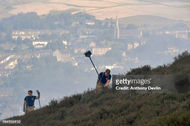 Fire officers use beaters to fight a large wildfire on the moors above Stalybridge, Greater Manchester on June 27, 2018 in Stalybridge, England....