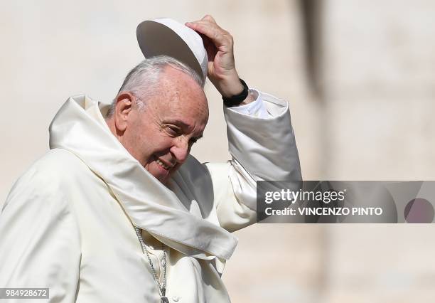 Pope Francis holds his Zucchetto as he arrives in St. Peters square at the Vatican for his weekly general audience on June 27, 2018