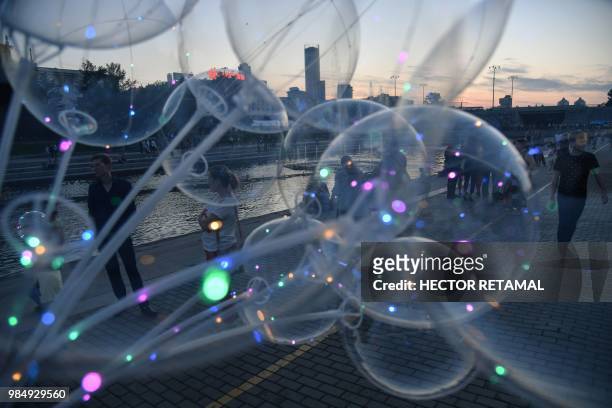 In this picture taken on June 26 people walk along the Iset River in Ekaterinburg, one of the host cities of the Russia 2018 World Cup football...