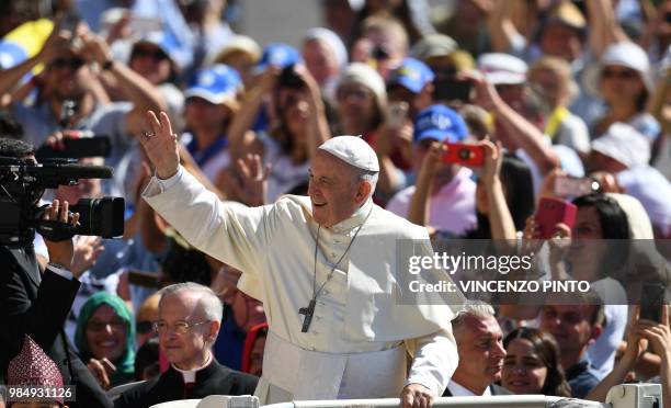 Pope Francis waves to the congregation as he arrives in St. Peters square at the Vatican for his weekly general audience on June 27, 2018