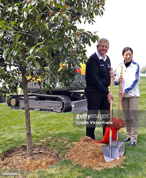 Colin Montgomerie of Scotland and Miss Xu Hong, Chairperson of Jinji Lake Golf Club, pose for the media after planting a tree during the Round Two of...