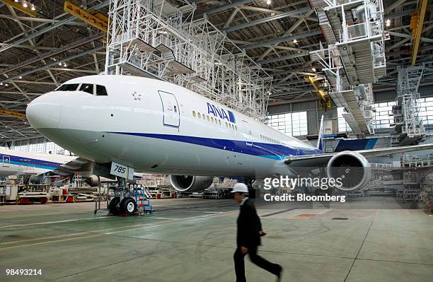 Member of the media walks past a newly delivered Boeing 777-300ER passenger jet for All Nippon Airways Co. In the company's hanger at Narita Airport...