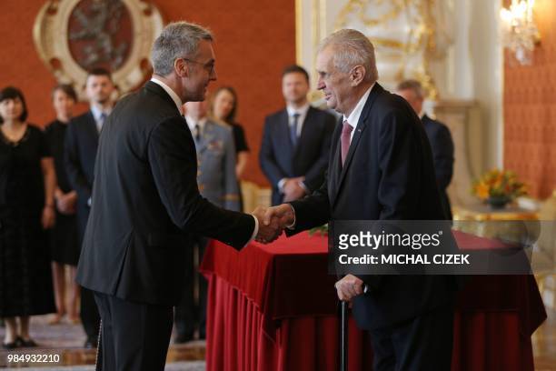 The new Czech Defence Minister Lubomir Metnar shakes hands with Czech President Milos Zeman after he was appointed as the new Czech government during...