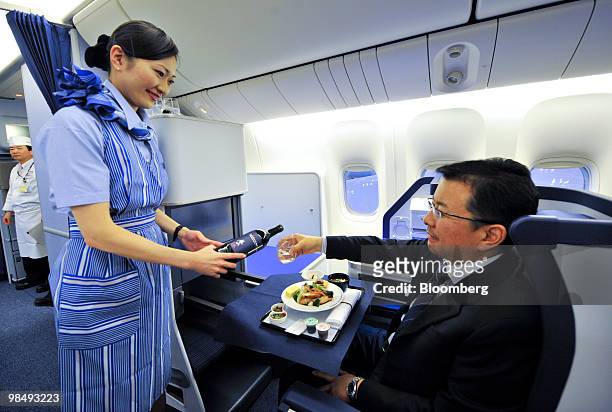 Flight attendant demonstrates All Nippon Airways Co.'s new branded service "Inspiration of Japan" inside the business class cabin of a Boeing...
