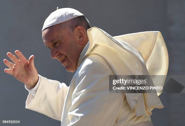 Pope Francis waves as he arrives at the St. Peters square at the Vatican for his weekly general audience on June 27, 2018.