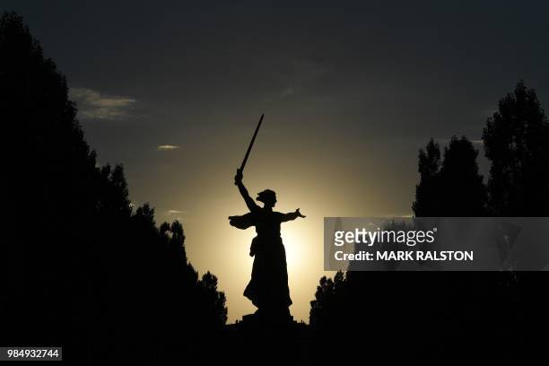 This picture taken on June 26, 2018 shows people at the base of the Motherland Calls statue at the Mamayev Kurgan World War II memorial complex in...