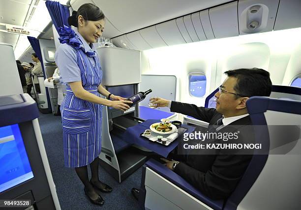 Employees of Japan's All Nippon Airways introduce the Business class seats in the company's new passenger plane Boeing 777-300ER during a press...