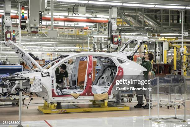 Employees assemble a Jaguar E-Pace compact sport utility vehicle on the production line at the second phase of the Chery Jaguar Land Rover Automotive...