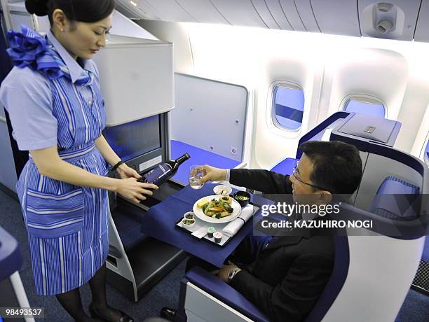 Employees of Japan's All Nippon Airways introduce the Business class seats in the company's new passenger plane Boeing 777-300ER during a press...