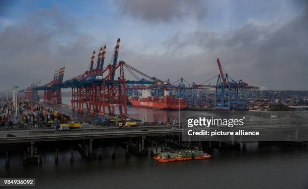 Container ship from the Hamburg Sued shipping company lying at anchor by the container bridge cranes of the Burchardkai by the A7 motorway in...