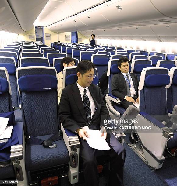 Employees of Japan's All Nippon Airways introduce the Economy class seats in the company's new passenger plane Boeing 777-300ER during a press...