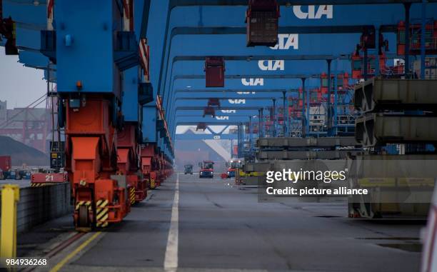 Containers being loaded onto electric transport vehicles by the container bridge cranes of the HHLA company in Altenwerder, Hamburg, Germany, 23...