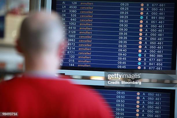 Passenger looks at canceled flights listed on an information board in Terminal 1 in Frankfurt International Airport in Frankfurt, Germany, on Friday,...