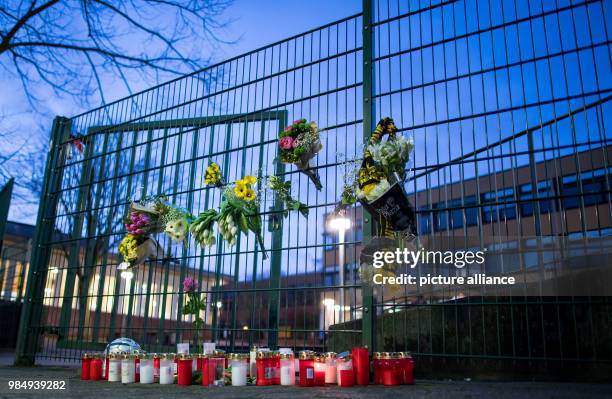 An der Käthe-Kollwitz-Gesamtschule in Lünen stehen am Trauerkerzen vor der Schule und am Zaun hängen mehrere Blumensträuße und ein BVB-Schal. Ein...