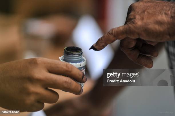 Resident put his finger into an ink container, after casting his vote in Tangerang, Indonesia on June 27, 2018. Today 152 million more Indonesians...