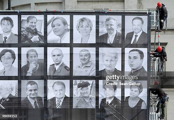 Workers attach a giant screen showing photographs of some of the 96 people killed in the recent Polish presidential plane crash in Smolensk at...