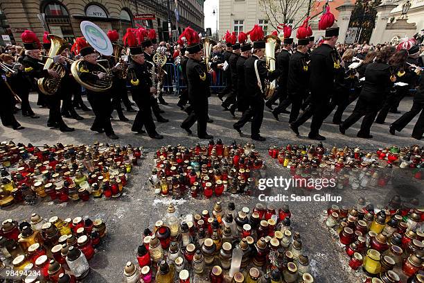 Polish miners' marching band marches past candles left by mourners in memory of late Polish President Lech Kaczynski and his wife Maria outside the...