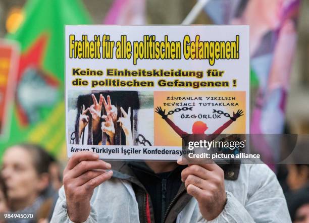 Pro-Kurdish participants carry banners and signs reading 'Freiheit für alle politischen Gefangenen!' during a rally against the Turkish war...