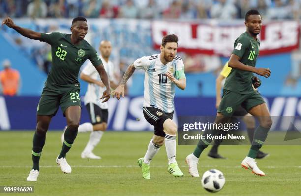 Argentina's Lionel Messi alongside John Obi Mikel and Kenneth Omeruo of Nigeria chases the ball during the first half of Argentina's 2-1 win in a...