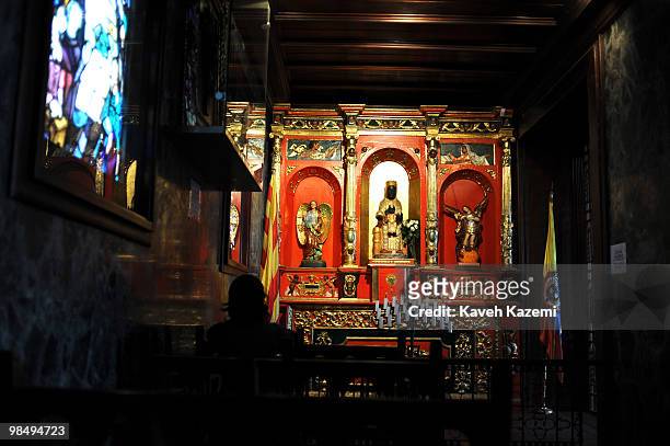 Woman prays in a chapel in front of a statue of Virgin Mary depicted as Black Maddona inside Monserrate church. Monserrate has held religious...