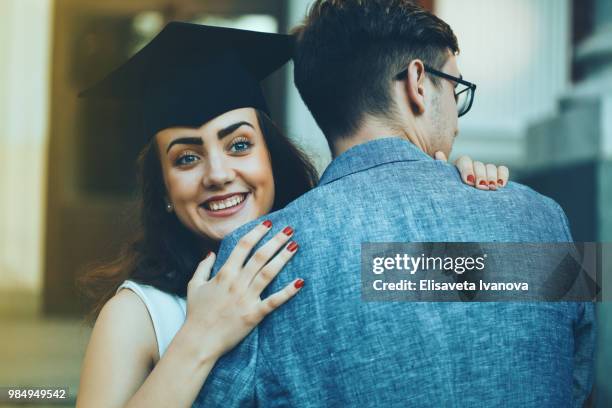 happy graduate girl giving a hug to a friend - animated graduation cap stock pictures, royalty-free photos & images