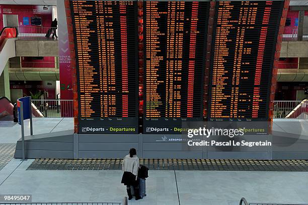 Passenger looks at flight information board which indicates cancelled flights in a terminal at the Charles-de-Gaulle airport in Roissy on April 16,...