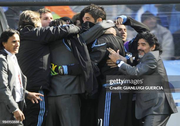 Argentina's coach Diego Maradona celebrates with team members after an Argentina free kick was deflected off of South Korea's striker Park Chu-Young...