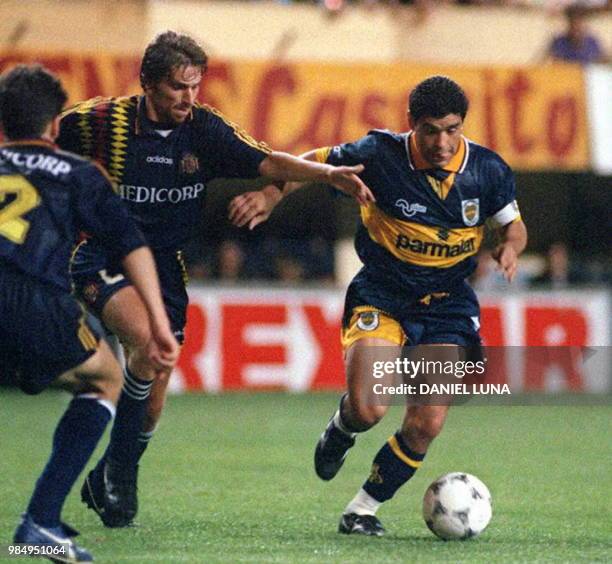 El futbolista Diego Maradona del Boca Juniors de Buenos Aires, intenta superar la marcacion de 2 no identificados rivales del Deportivo Espanol, 17...