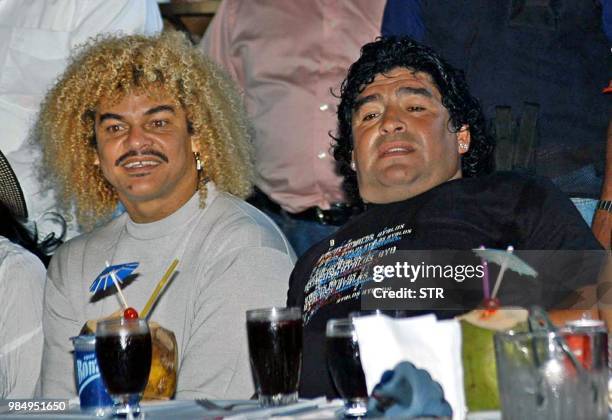 Soccer stars of Colombia Carlos Valderrama and Argentina, Diego Maradona look at a traditional dance 31 January 2004 in Barranquilla during a...