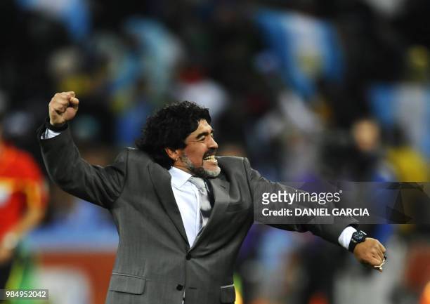 Argentina's coach Diego Maradona celebartes after Argentina's striker Carlos Tevez scored a third goal for his team during the 2010 World Cup round...