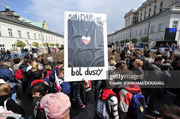 Mourner holds a placard reading "Solidarity , the soul's pain" referring to the death of Solidarity "godmother" Anna Walentynowicz, in front of a...