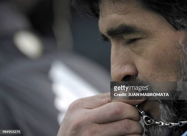 Argentina's coach Diego Maradona kisses his crusifix before the start of a friendly football match against Canada at the Monumental stadium in Buenos...