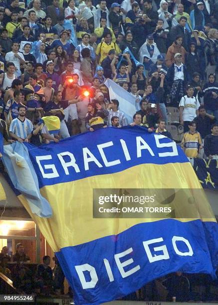 Fans of Argentina's Boca Juniors wave a flag in honor of Argentine soccer star Diego Armando Maradona before a soccer match in Mexico City 07 June,...