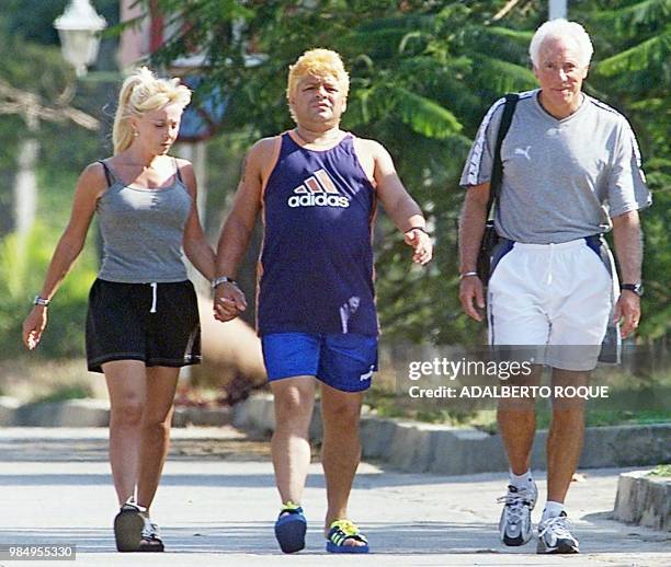 Former Argentine soccer star Diego Armando Maradona , his wife Claudia Villafane and attorney Guillermo Coppola go for a walk 28 January 2000 in...