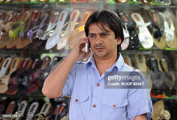 Kashmiri pedestrian speaks on a cellular telephone in Srinagar on April 16, 2010. India has restricted mobile phone users in Kashmir from sending SMS...
