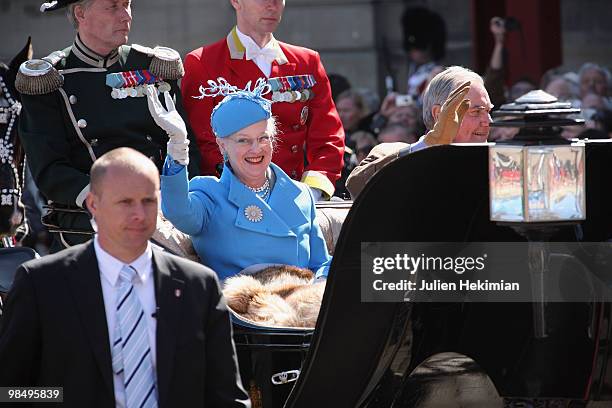 Queen Margrethe of Denmark waves to wellwishers from a carriage next to Prince Consort Henrik during celebrations marking her 70th birthday on April...