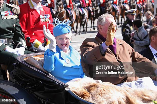 Queen Margrethe of Denmark waves to wellwishers from a carriage next to Prince Consort Henrik during celebrations marking her 70th birthday on April...