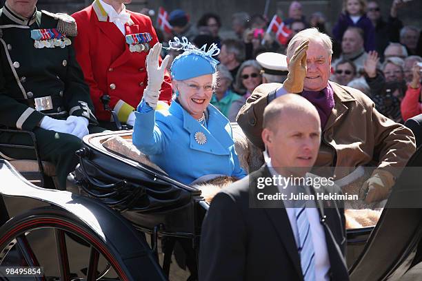 Queen Margrethe of Denmark waves to wellwishers from a carriage next to Prince Consort Henrik during celebrations marking her 70th birthday on April...