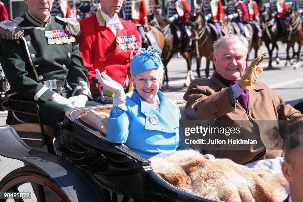 Queen Margrethe of Denmark waves to wellwishers from a carriage next to Prince Consort Henrik during celebrations marking her 70th birthday on April...