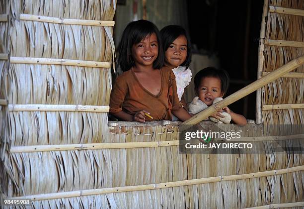 Children looks out of a window at a fishing village of Pilar, Siargao Island southern Philippines on April 16, 2010. Fourteen countries participate...