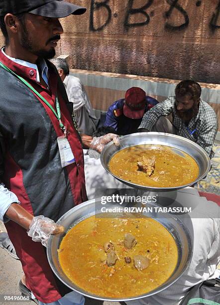 Pakistani volunteer distribute charity food to the needy on a street in Karachi on April 16, 2010. Seventeen million Asians have fallen into extreme...